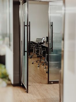 A stylish conference room featuring open glass doors and sleek furniture for a professional setting.