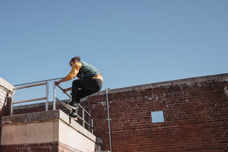 Young Man Climbing On Roof