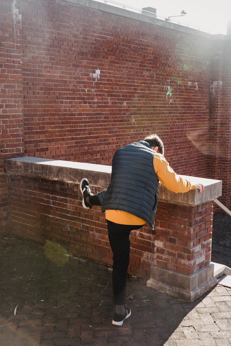 Anonymous Man Jumping Over Brick Border