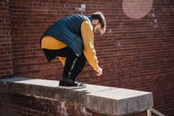 Full length of young male in casual clothes performing stunt while practicing parkour on street of city