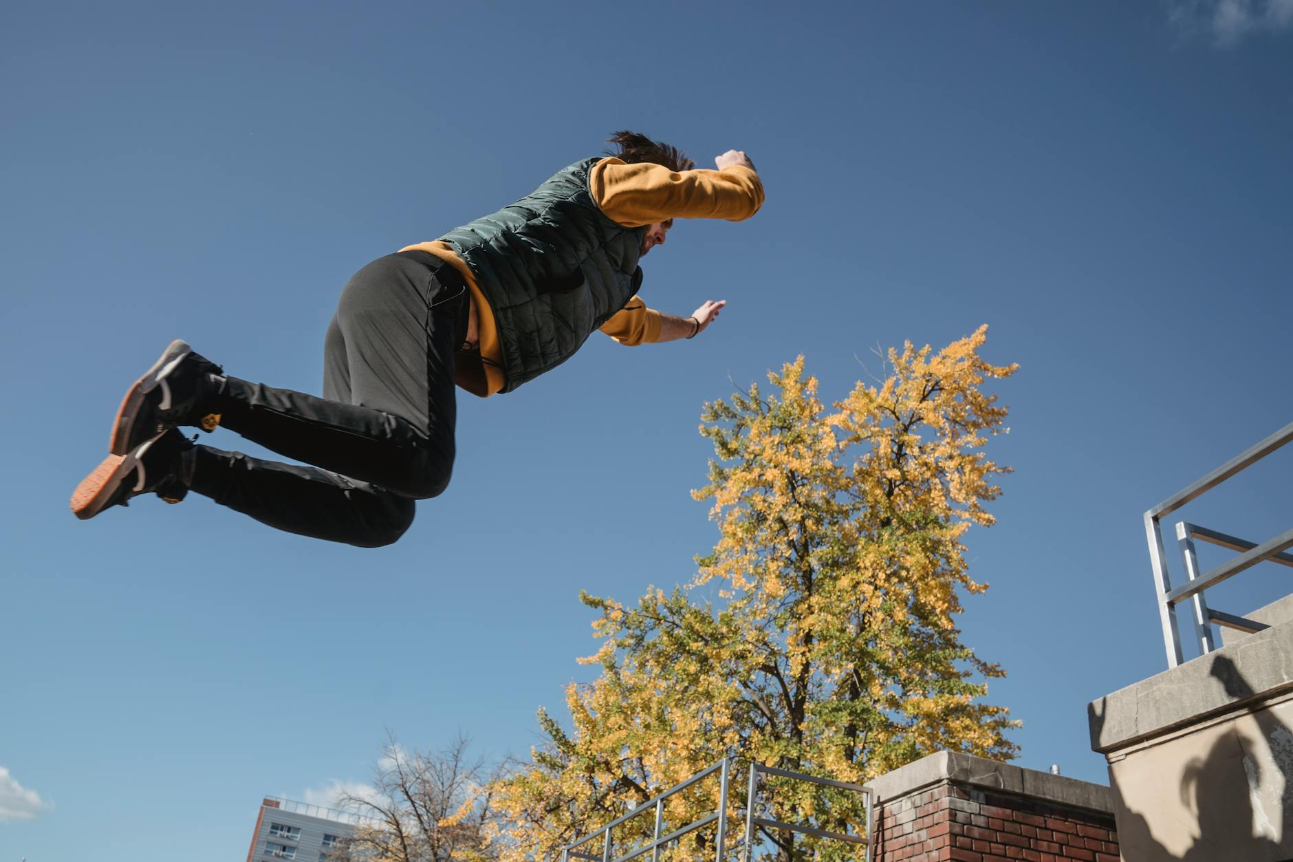 Strong faceless man jumping on roof · Free Stock Photo