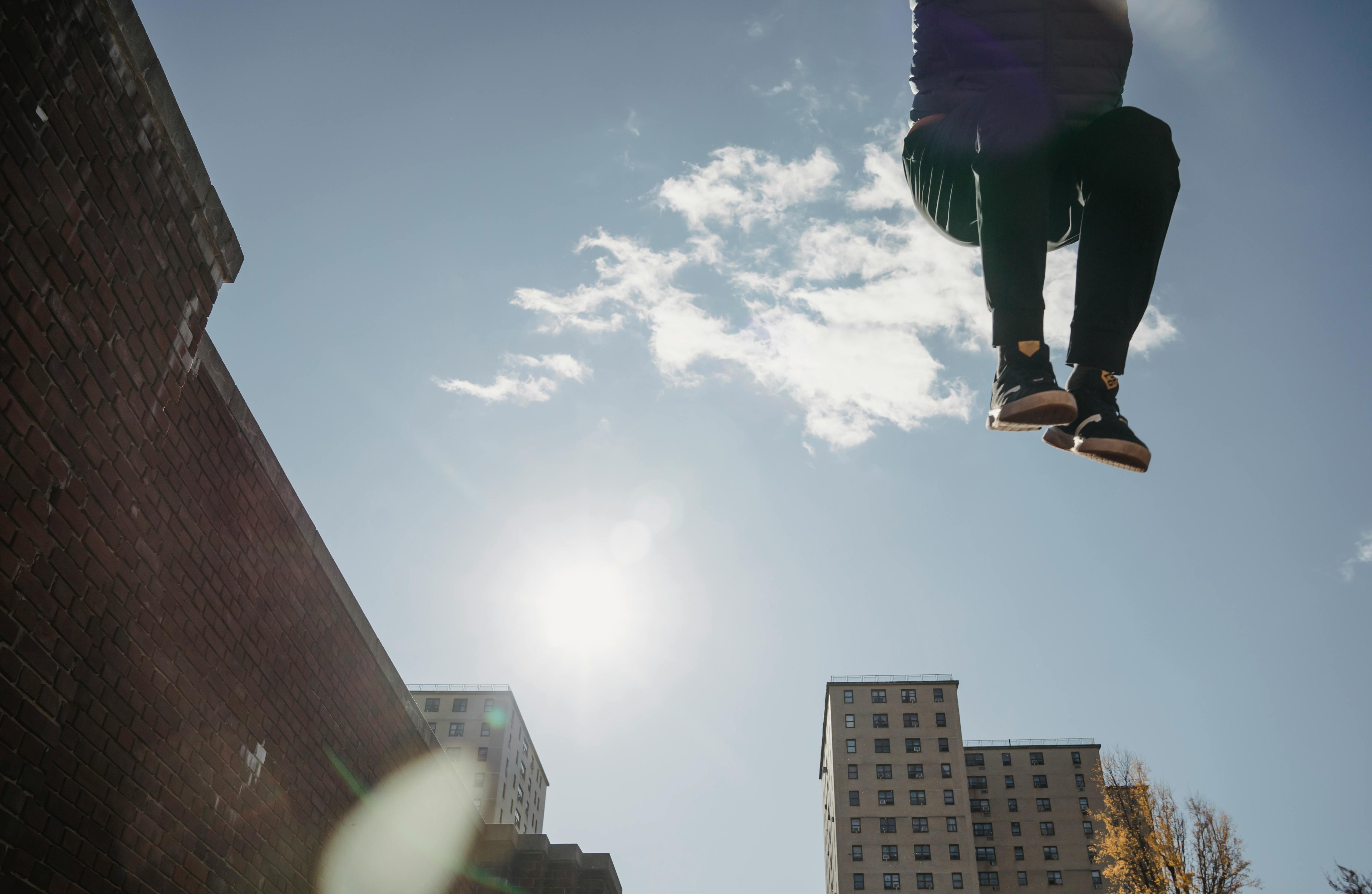 Anonymous man jumping high near building · Free Stock Photo