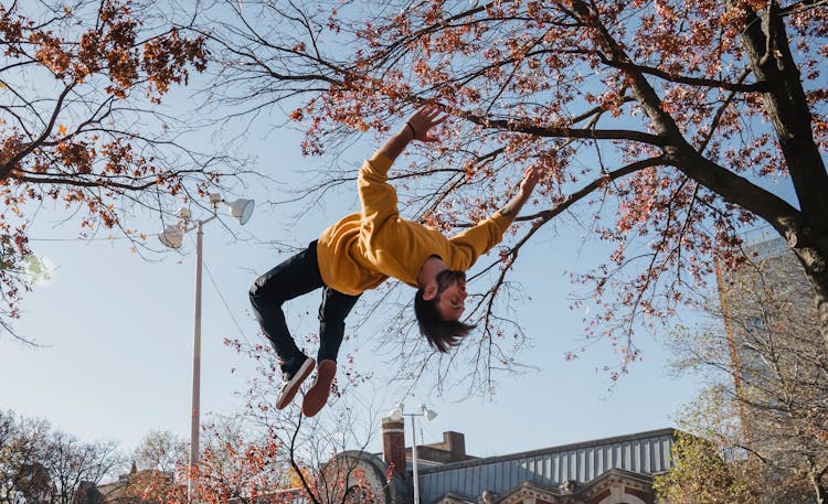 Guy Doing Backflip In City Park