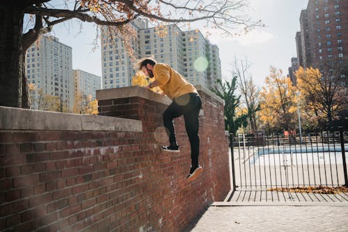 Free Man jumping on fence in city park Stock Photo