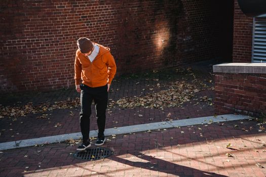 Faceless man standing on street near at road drain