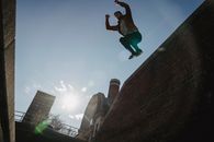 Determined male tracer jumping from brick wall