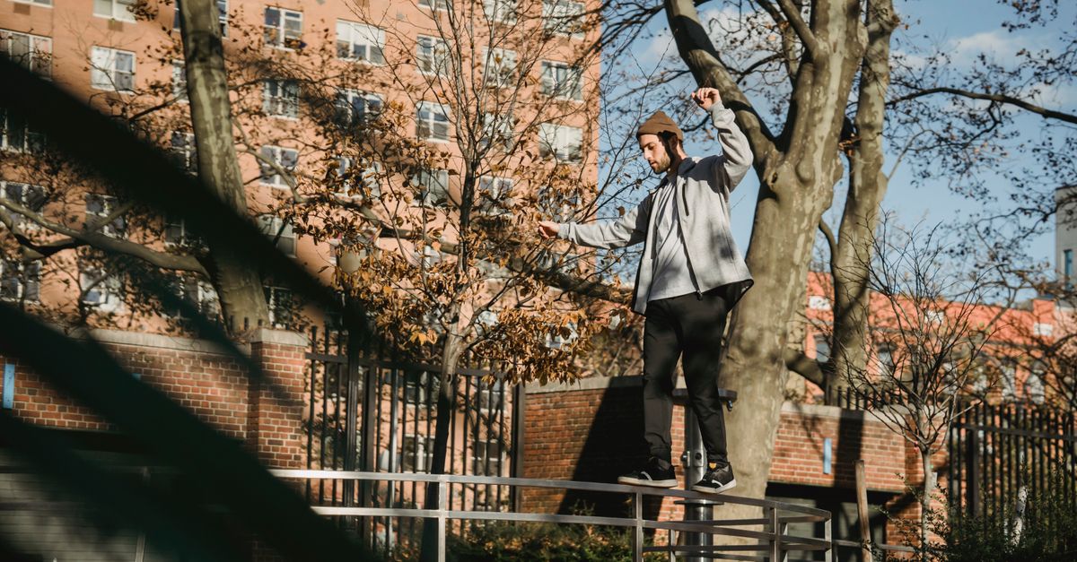 Balancing On Railing Male balancing on railing in park near buildings in town · Free Stock Photo