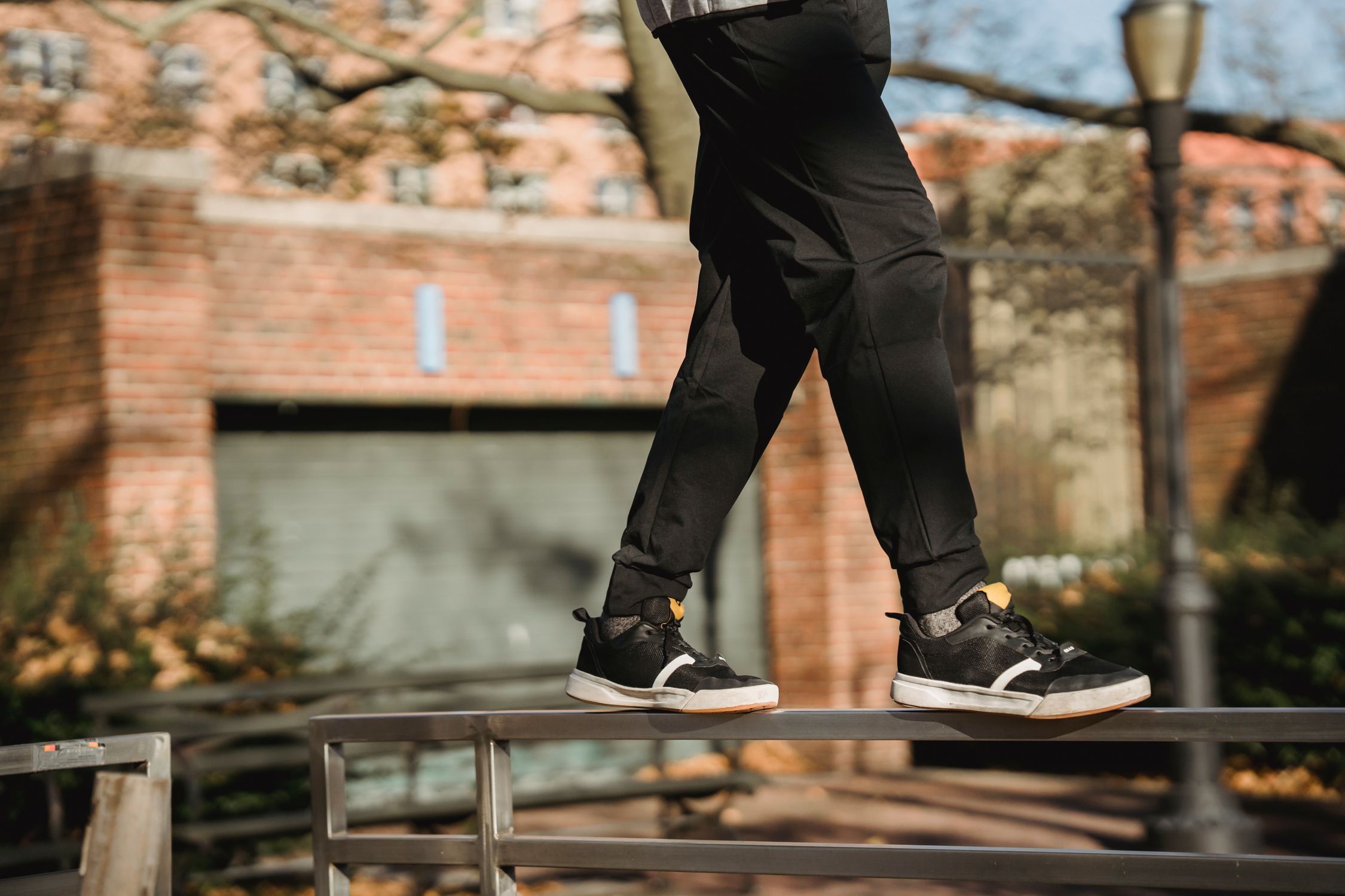 Balancing On Railing Faceless man balancing on railing near buildings in park · Free Stock Photo