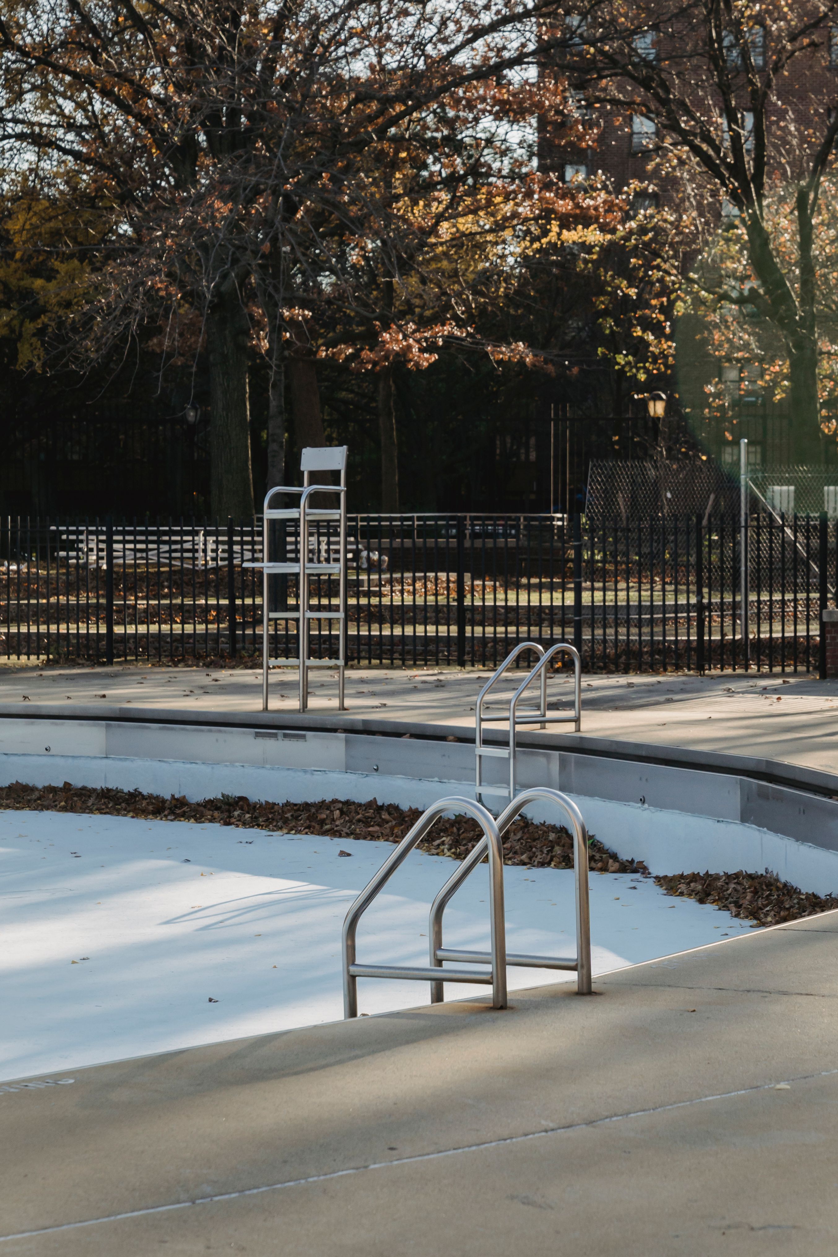 Do You Need a QBCC Licence for Fencing? Rules, Exemptions & Licence Classes Explained 5 Empty pool with a safety fence in a park during autu mn