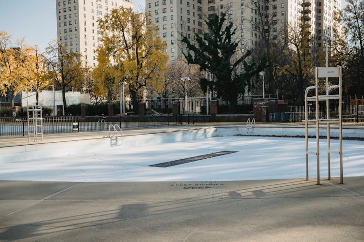 Empty Pool In Park In Fall Near Fence In City