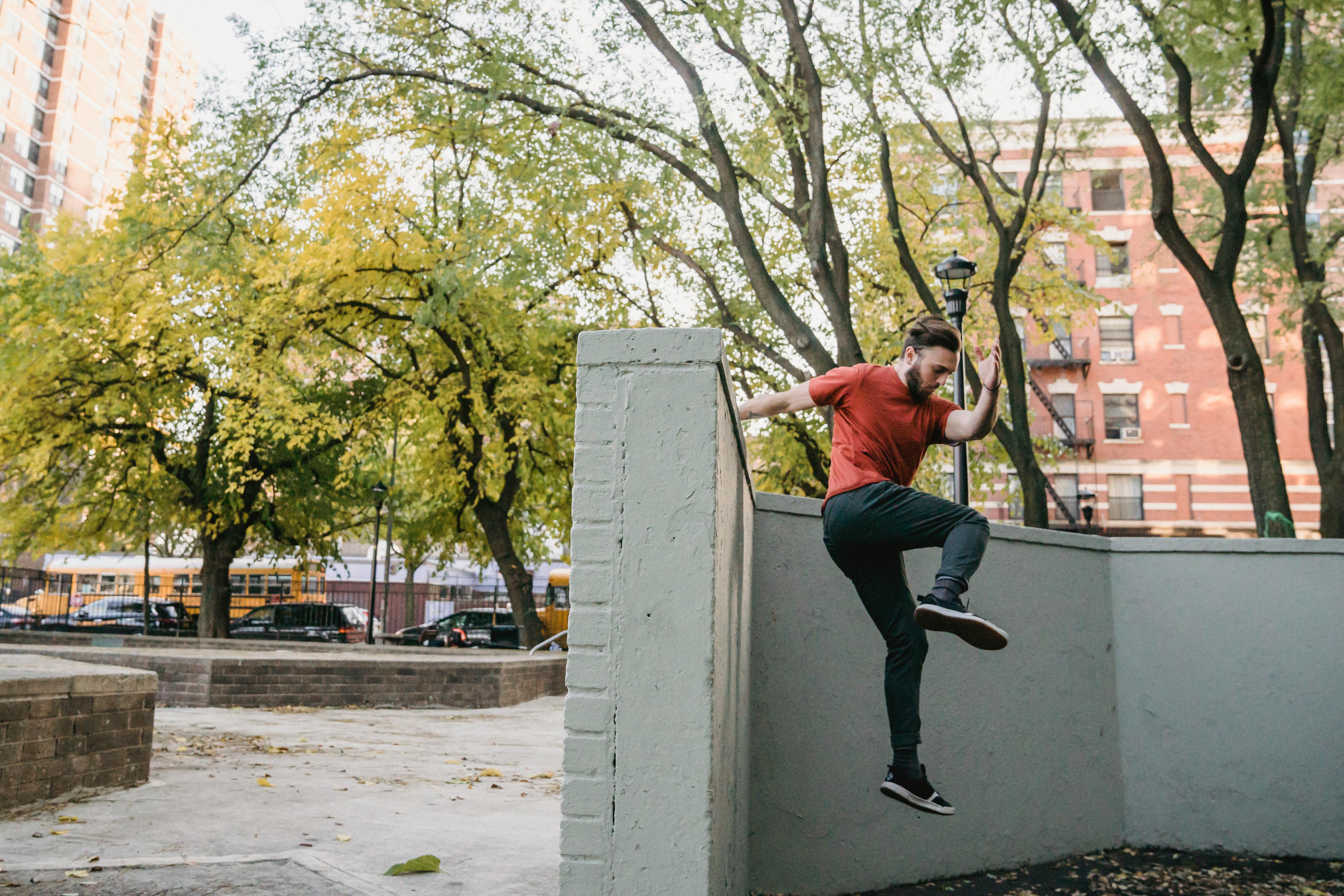 young man jumping off wall in street