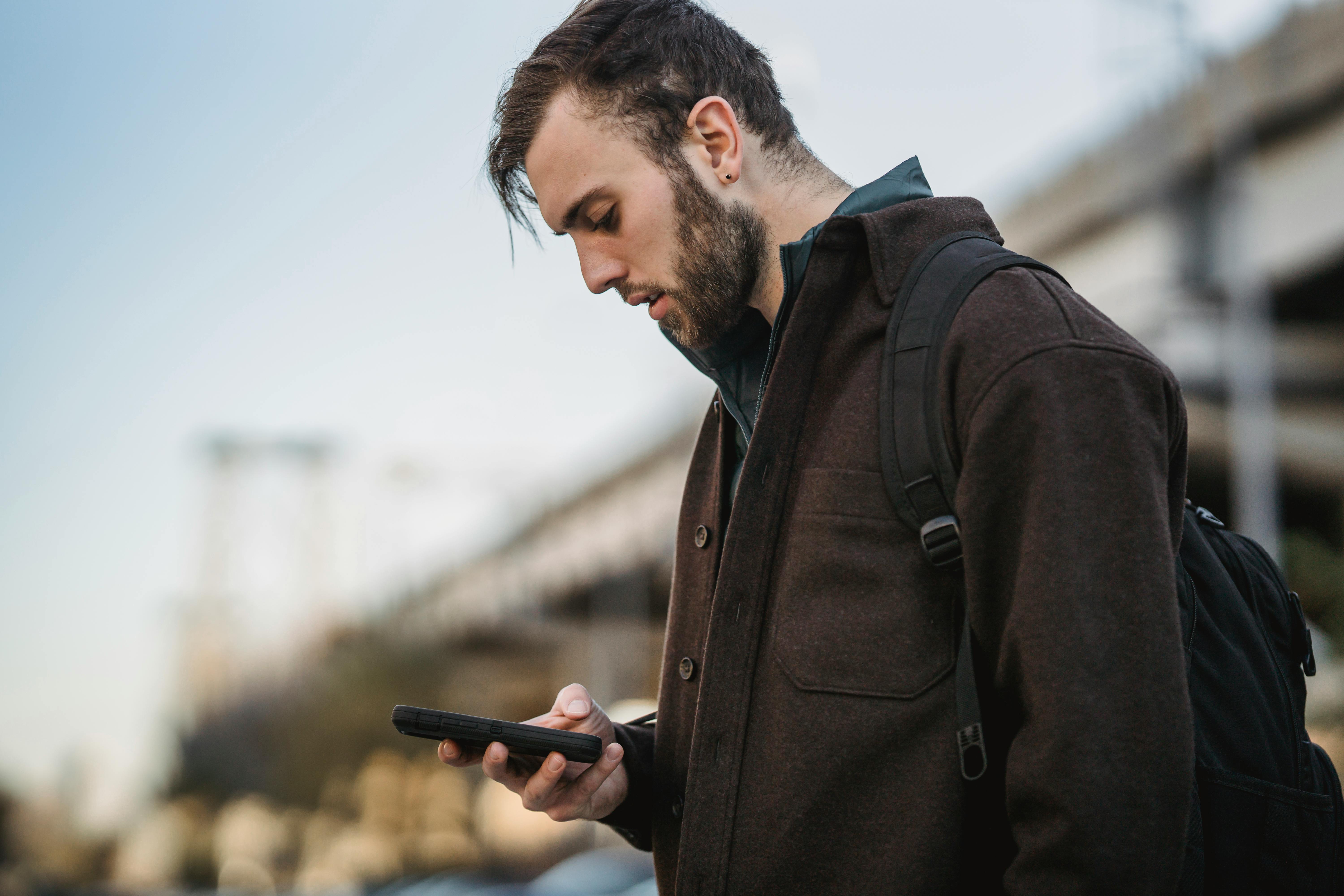 crop hipster man chatting on smartphone in city