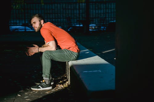 Free Dreamy hipster man resting on urban bench in sunlight Stock Photo
