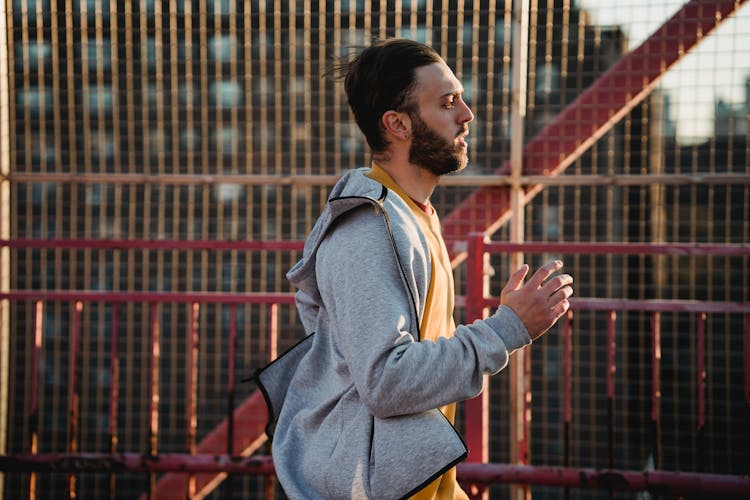 Male Runner Jogging On City Street In Evening