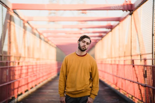 Cool hipster man in soft clothes on urban bridge