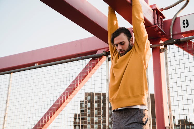 Strong Man Hanging On Metal Construction