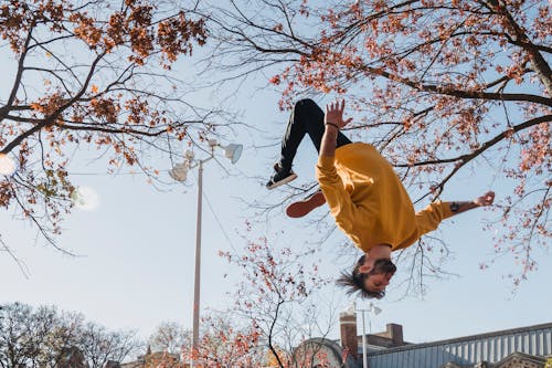 Flexible man doing flip on street