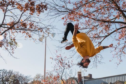 Flexible man doing flip on street