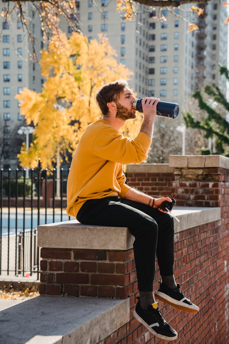 Thirsty Man Drinking Water On Barrier