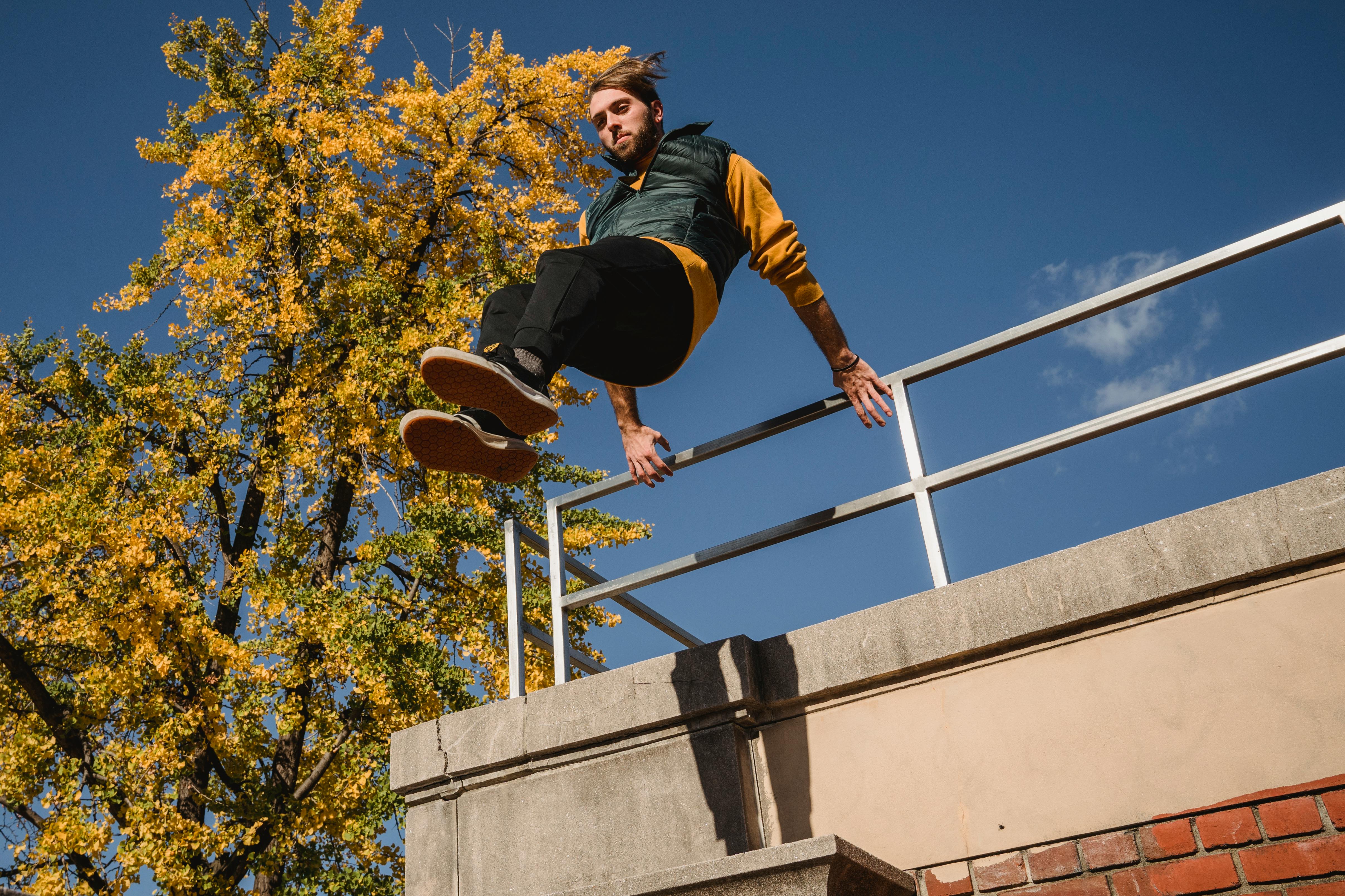 Gri Beton Duvara Tırmanan Siyah Ceket Ve Siyah Pantolonlu Adam