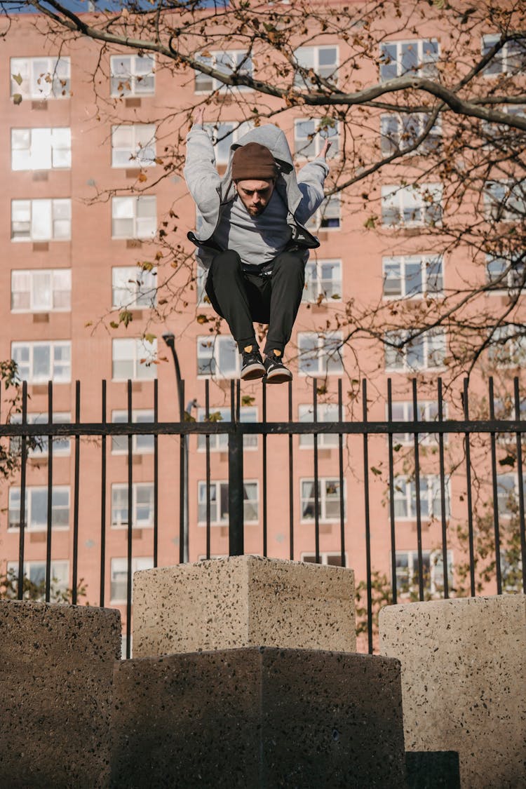 Sporty Man Jumping On Concrete Pillar