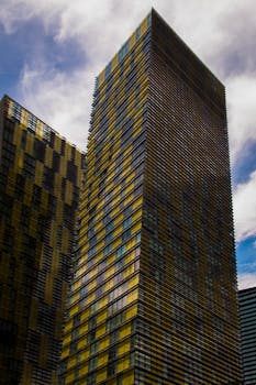 在多云的天空下，高大的现代摩天大楼呈现出引人注目的几何图案