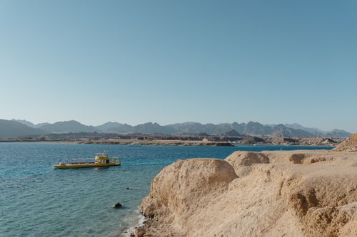 Free A beautiful coastal landscape featuring a vibrant yellow submarine against clear blue waters. Stock Photo