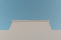 Bare White Building Facade against Blue Sky