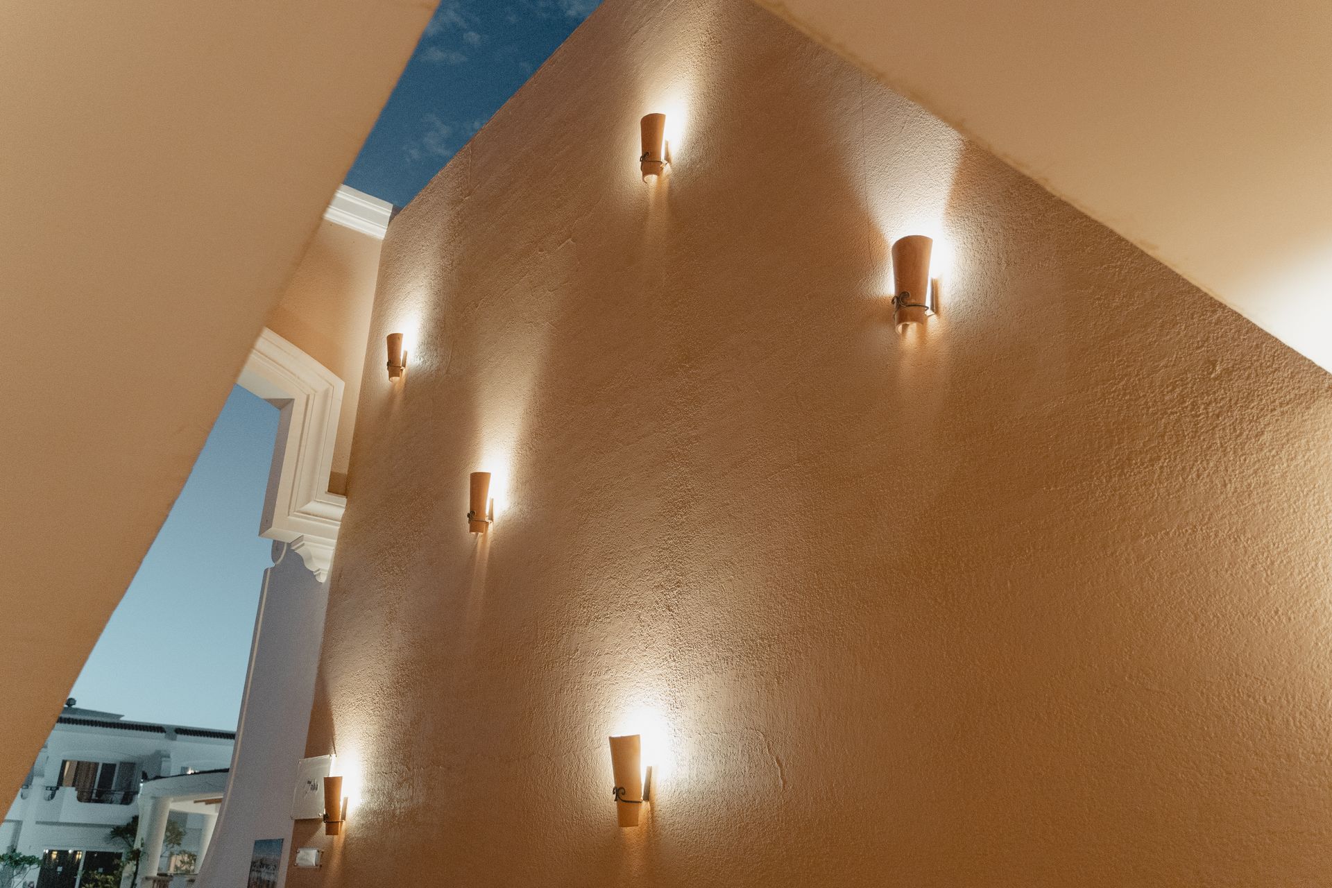 Elegant low angle shot of sconces lighting a beige interior wall, creating a warm and modern ambiance.