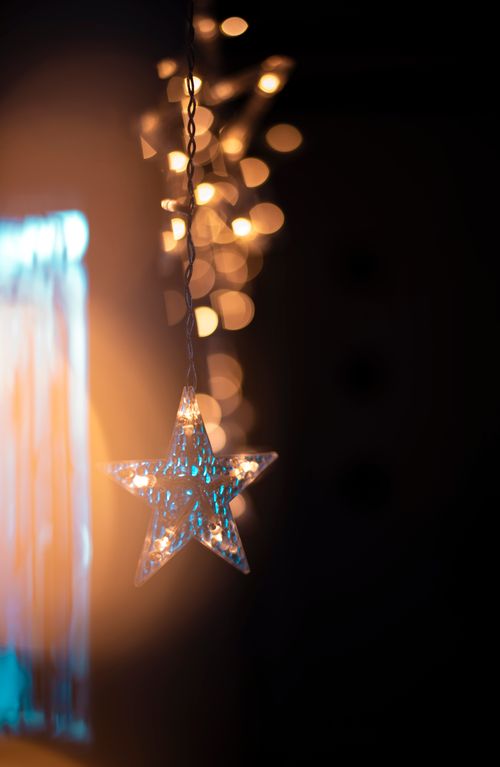 Free Glowing star shaped ornament with bokeh lights, perfect for Christmas decoration themes. Stock Photo
