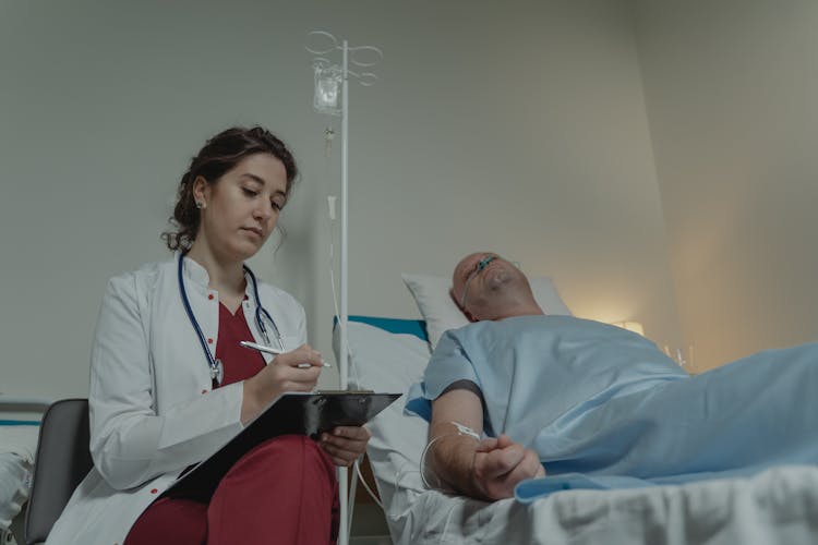 Doctor Sitting Beside A Patient