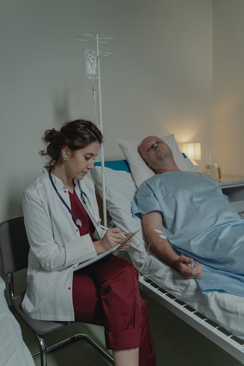 Free Doctor Sitting beside a Patient Stock Photo