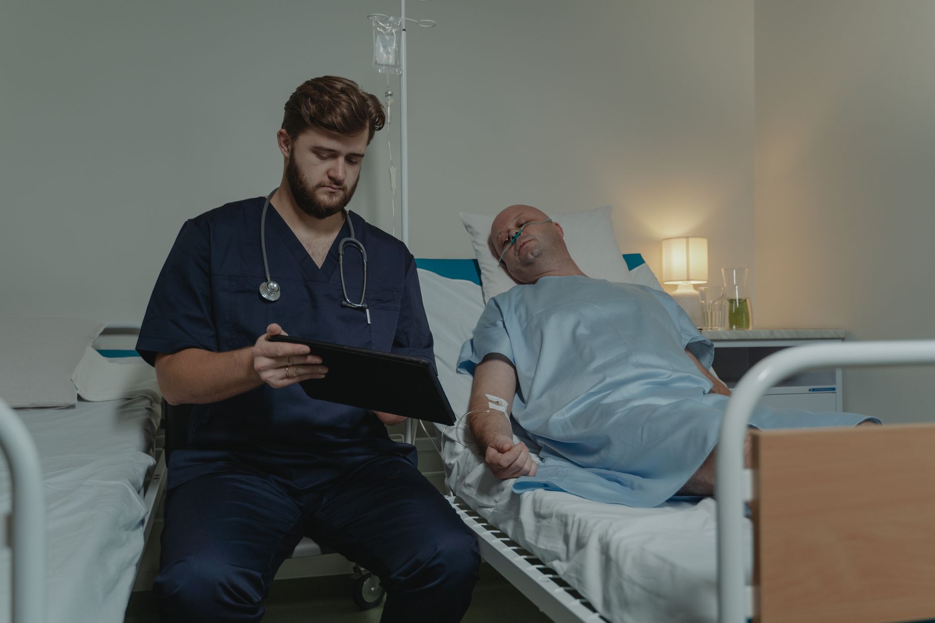 Doctor tending to a patient lying in a hospital bed, symbolizing healthcare challenges.