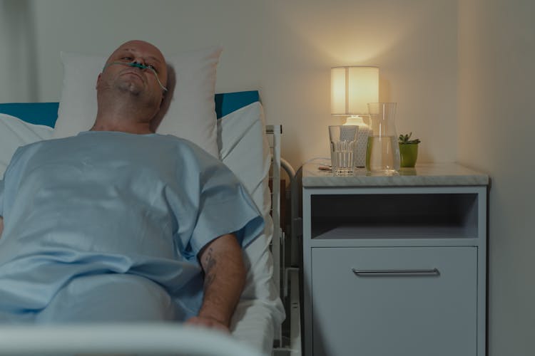 Sick Man Lying On Hospital Bed