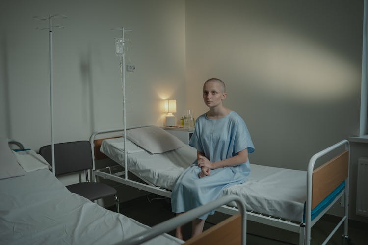 A Patient Sitting On The Hospital Bed