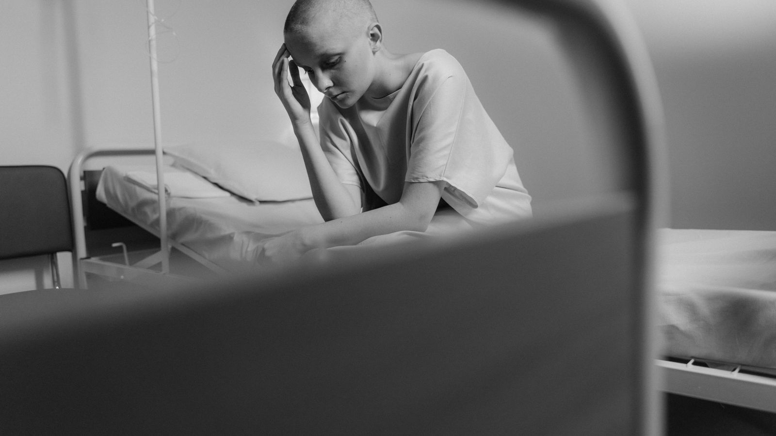 Emotional black and white photo of a woman in a hospital setting, representing vulnerability and courage.
