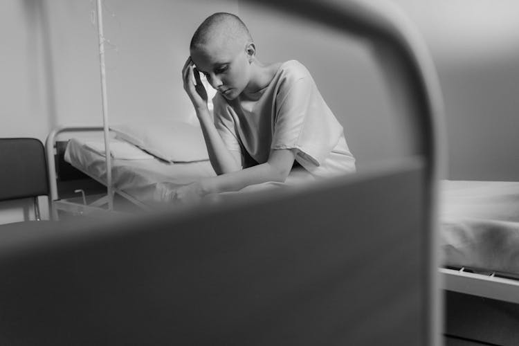 Bald Woman Sitting On The Hospital Bed