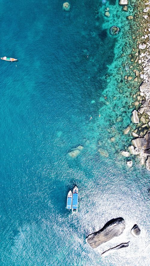 Free Stunning aerial shot of boats on turquoise waters near rocky shore in Koh Samui, Thailand. Stock Photo