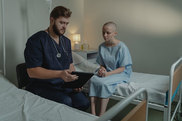 A Man And Patient Looking The Digital Tablet