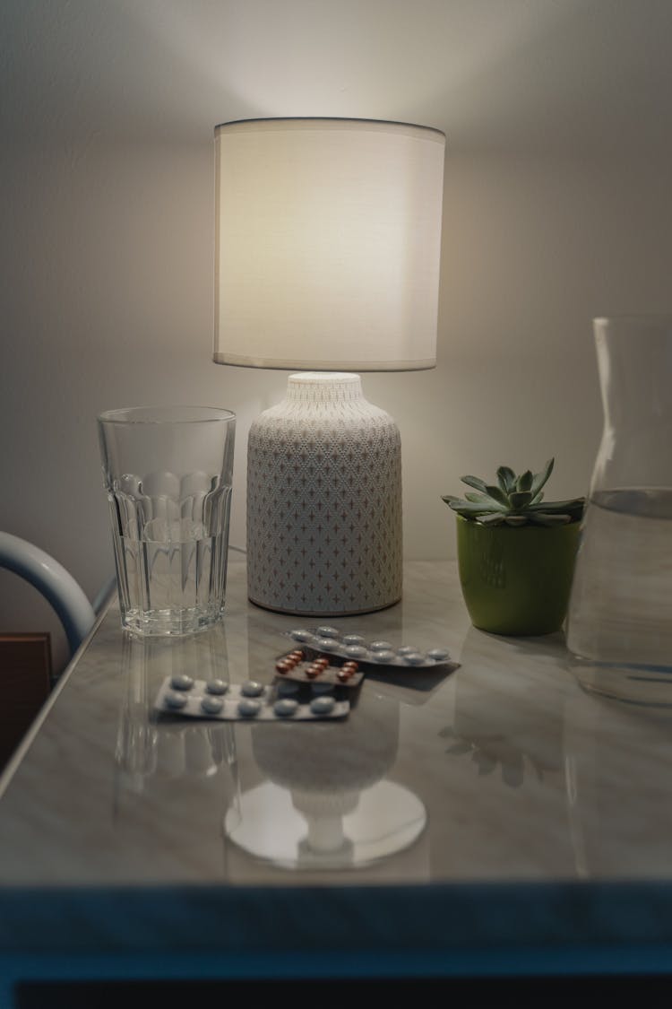 A Medicine And Lamp On The Table