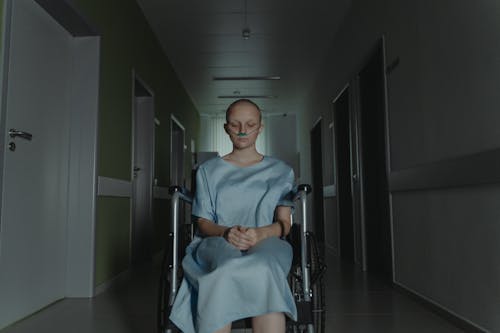 A Bald Woman Sitting on the Wheelchair