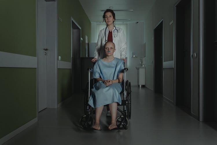 A Patient Sitting On The Wheelchair With Her Doctor