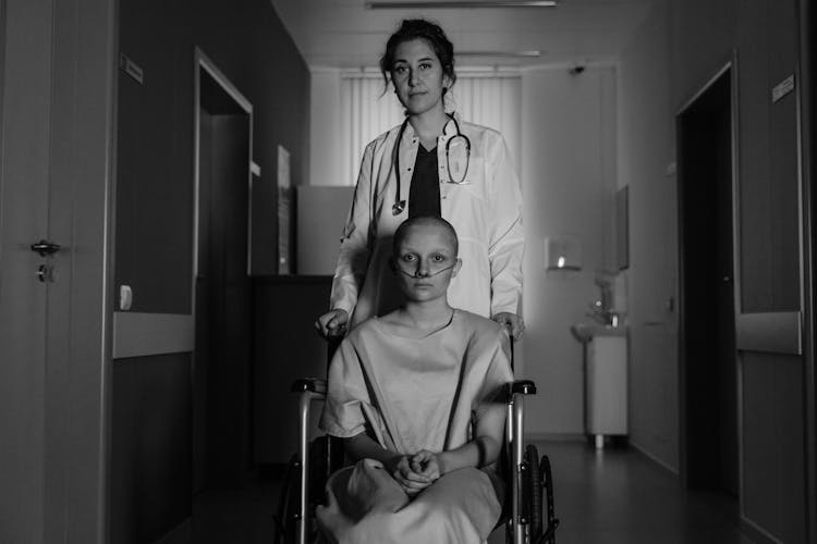 Doctor Behind A Patient On A Wheelchair