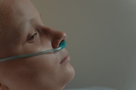 Profile of a woman with a nasal cannula in a serene hospital setting.