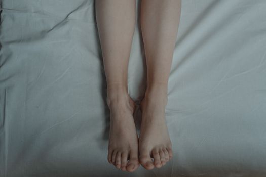 A pair of bare feet lying on a bed, capturing a serene and relaxed moment.