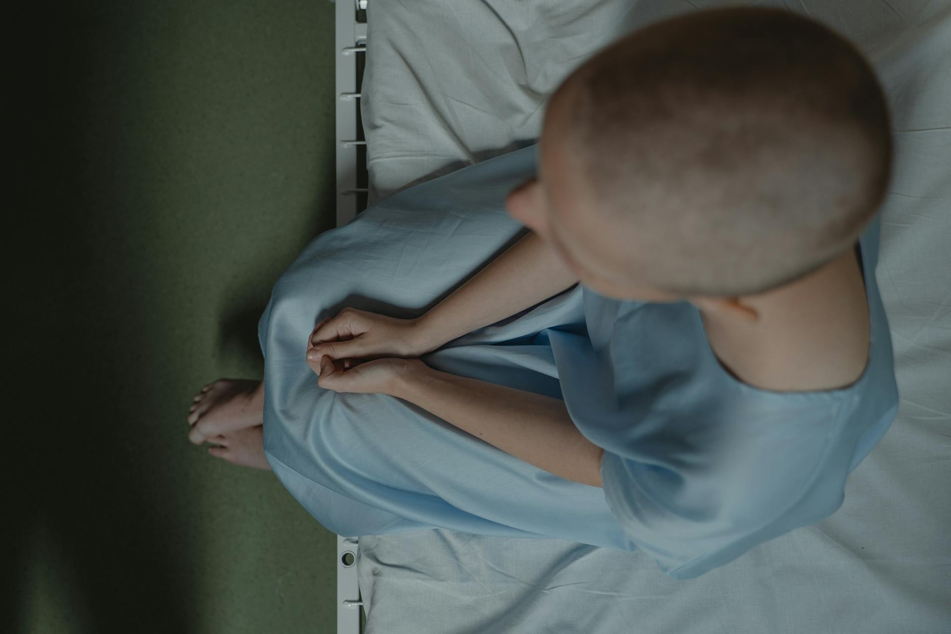 Cancer Patient Sitting on Hospital Bed