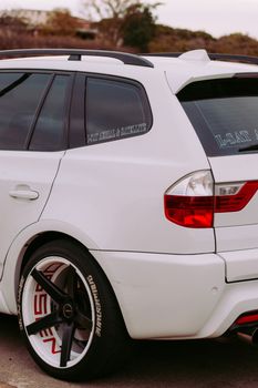 A white SUV showcasing sleek design and custom wheels, parked outdoors.