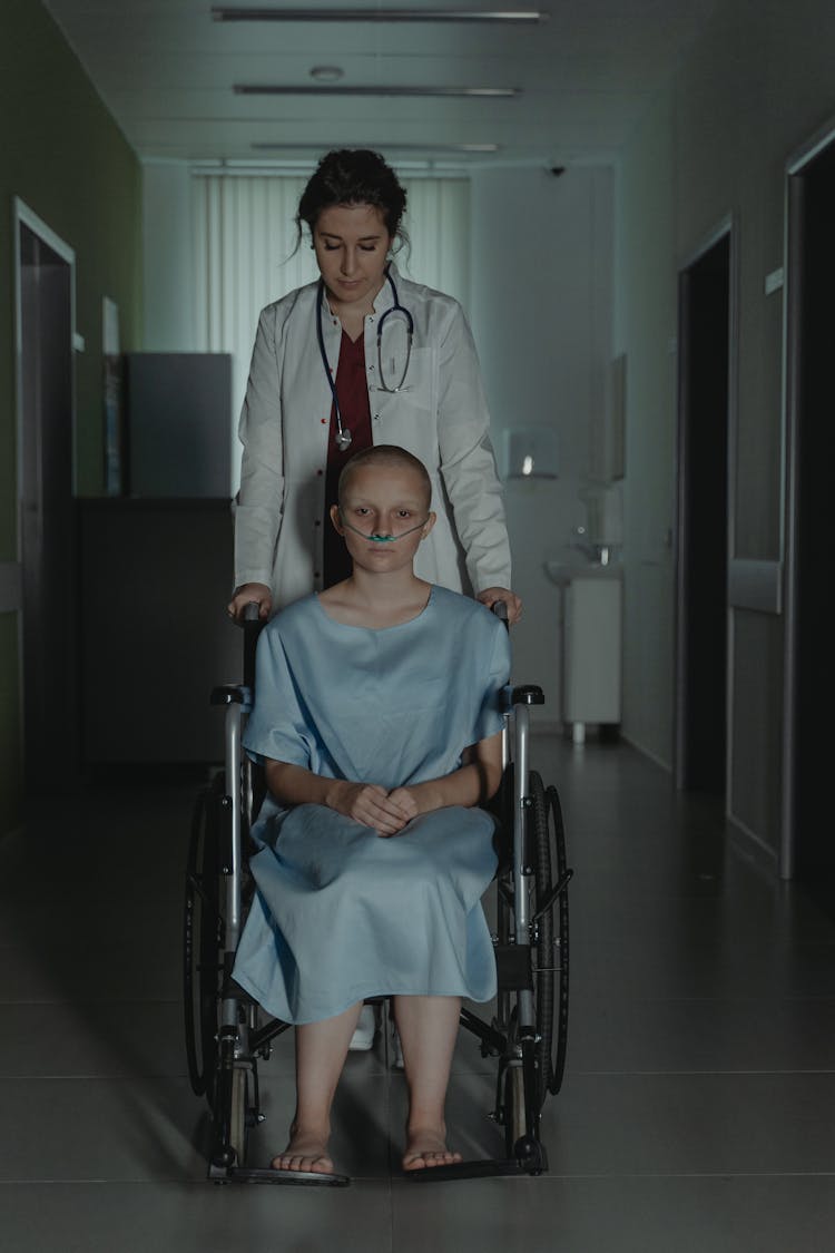 Doctor Pushing A Patient On A Wheelchair