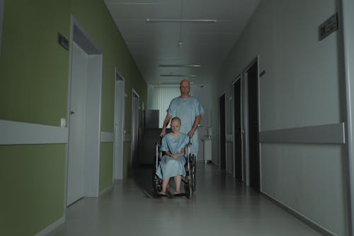 Foto d'estoc gratuïta de bata d'hospital, cadira de rodes, calb