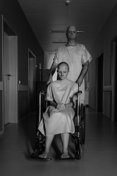 Grayscale Photo of a Woman Sitting on a Wheelchair